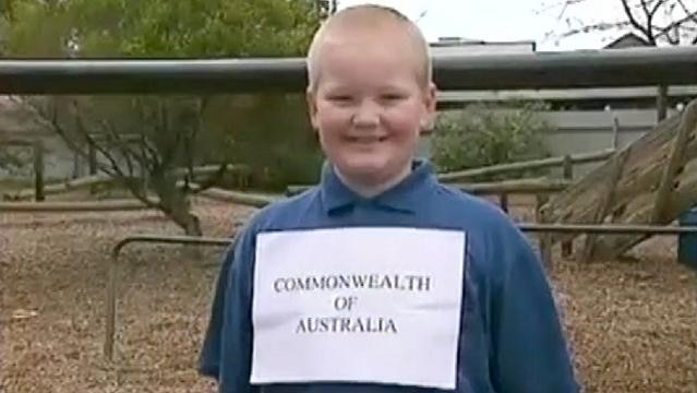 Boy wears sign with text Commonwealth of Australia