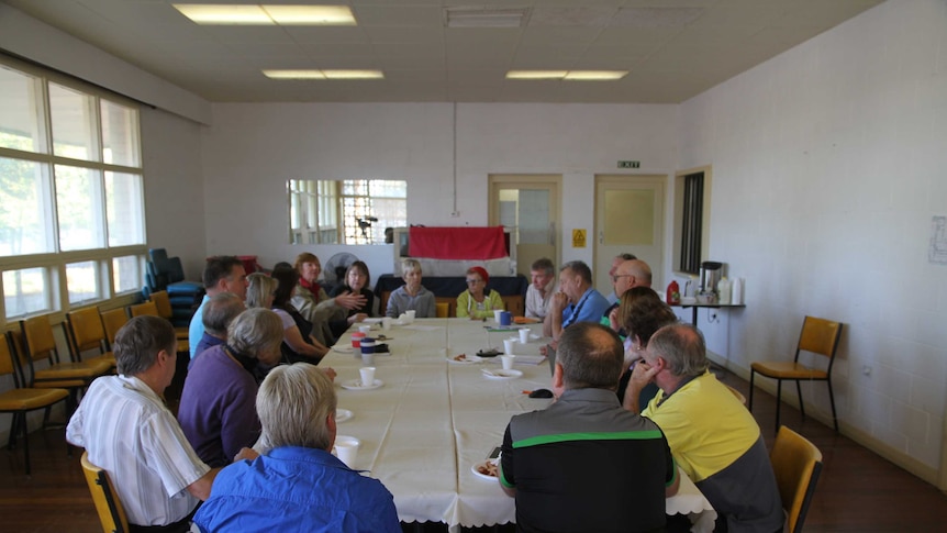 A group of Menindee locals seated around a table, taken from the end of the table.