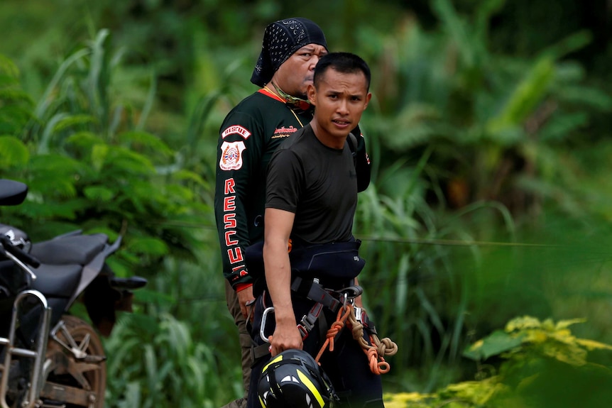 Cavers walk a road leading to the Tham Luang cave complex in the northern province of Chiang Rai