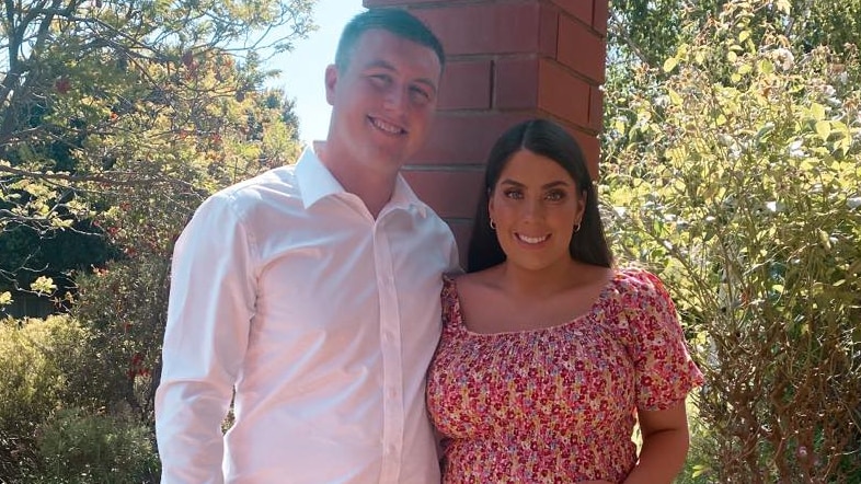 A man with a pregnant woman in an orange dress