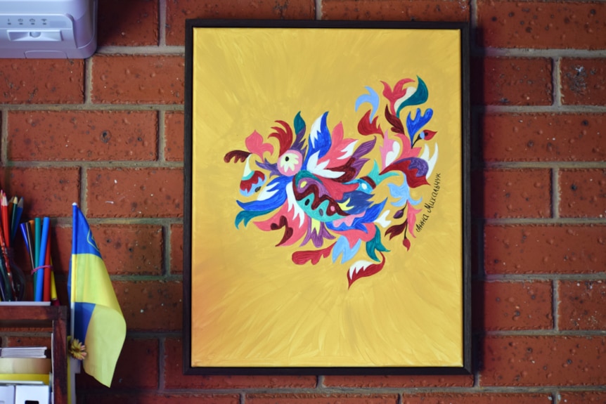 Painting on wall, yellow background and patterened/colourful image.