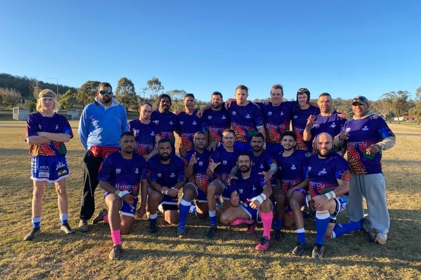 Sebuah tim pemain sepak bola dengan karya seni Aborigin di jersey mereka. 