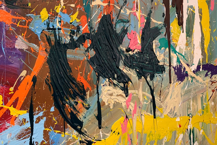 A colourful modern art painting has several ugly dashes of black paint across it.