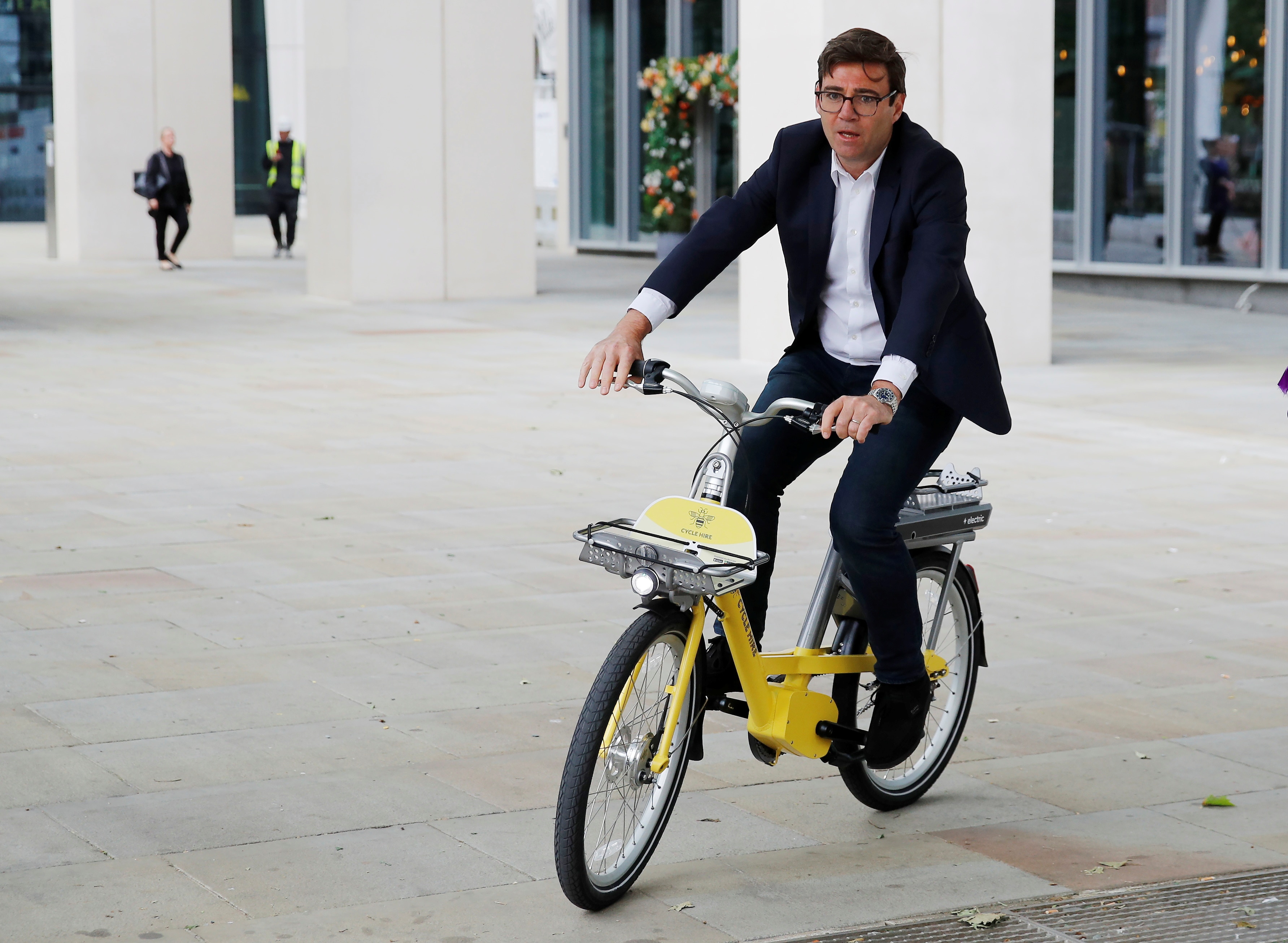 A man rides a yellow bike. 