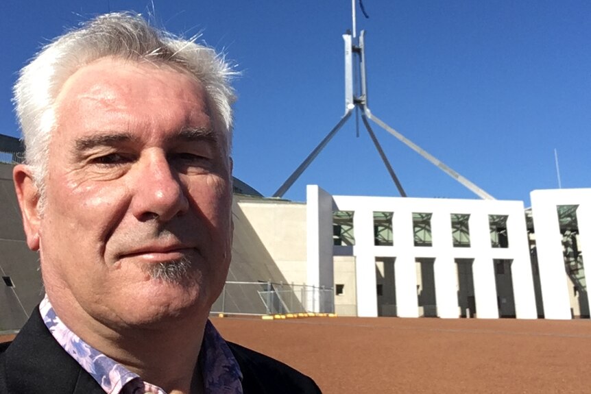 Adrian Pisarki stands in front of Parliament House in Canberra