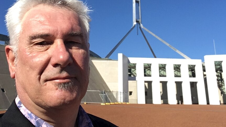 Adrian Pisarki stands in front of Parliament House in Canberra