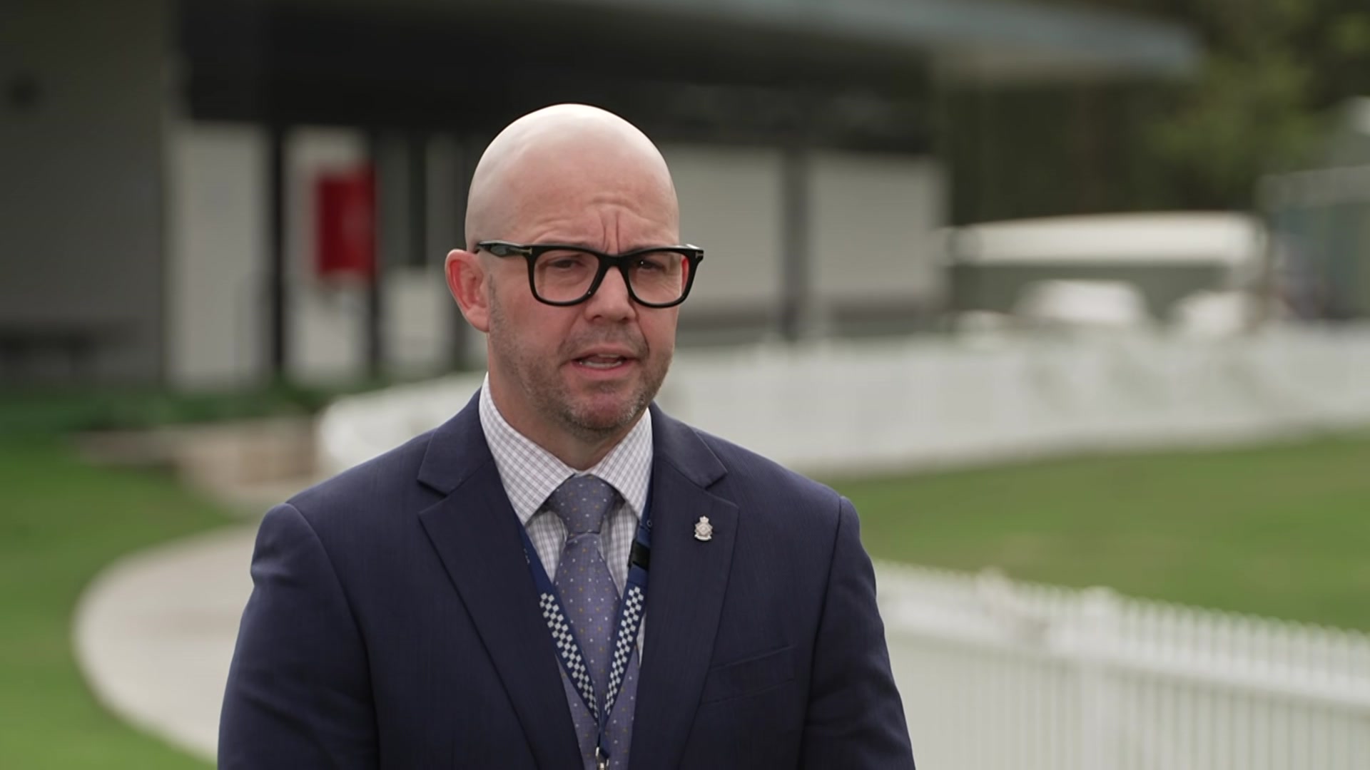 Shane Prior, a bald man with glasses, speaking. 