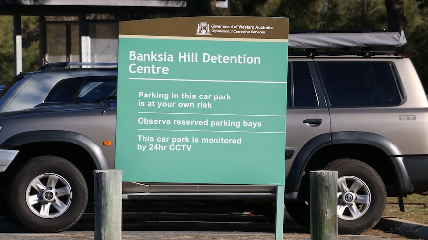 A Banksia Hill Detention Centre sign, with cars in the background.