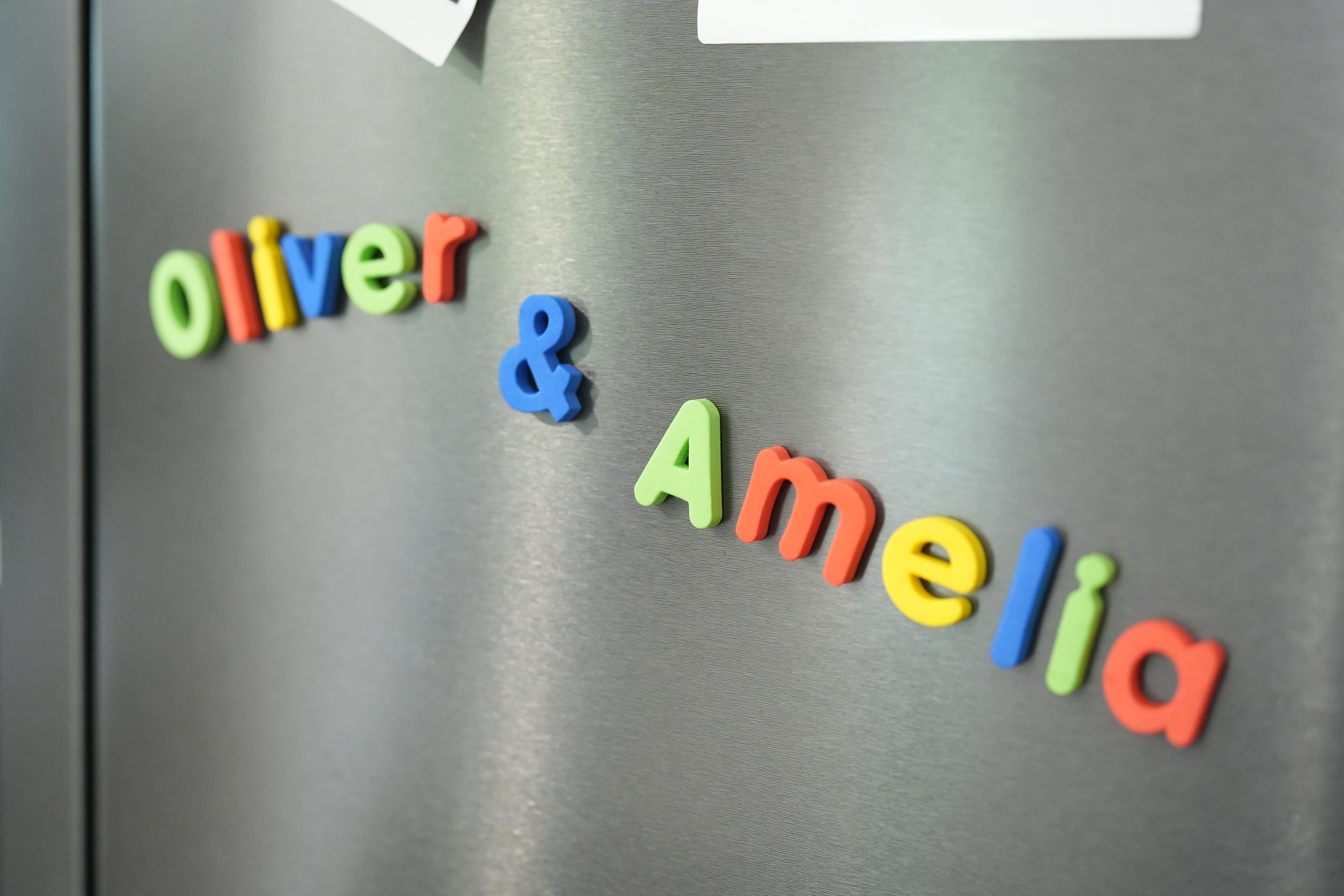 Los coloridos imanes de nevera con forma de letras explican: Oliver y Amelia.