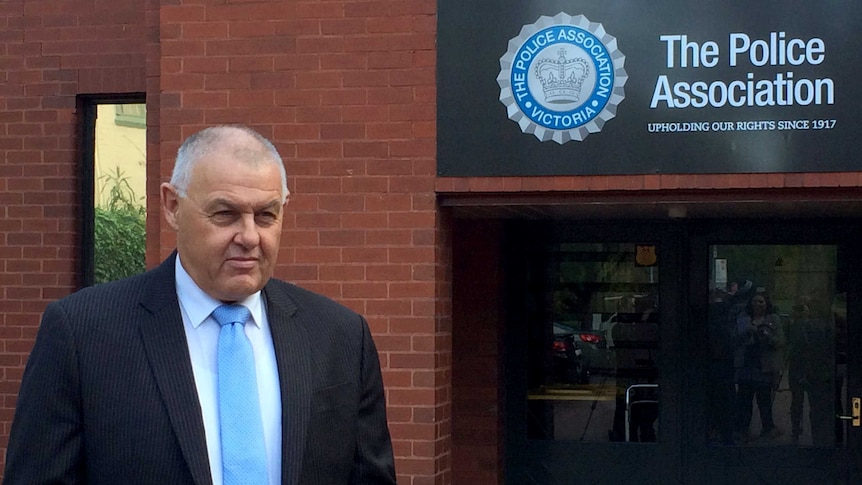 Ron Iddles standing outside the Police Association office with sign visible