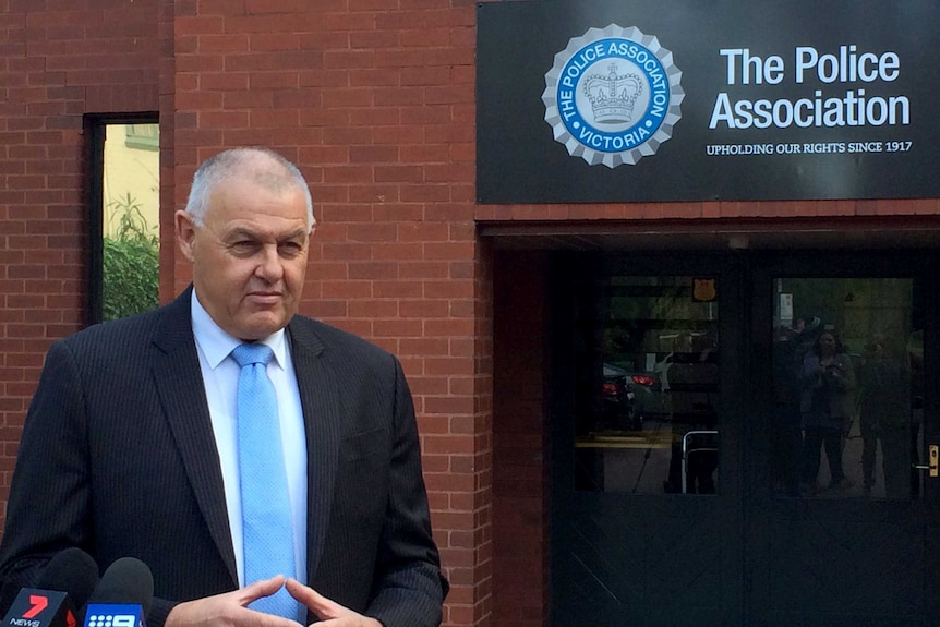 Ron Iddles standing outside the Police Association office with sign visible