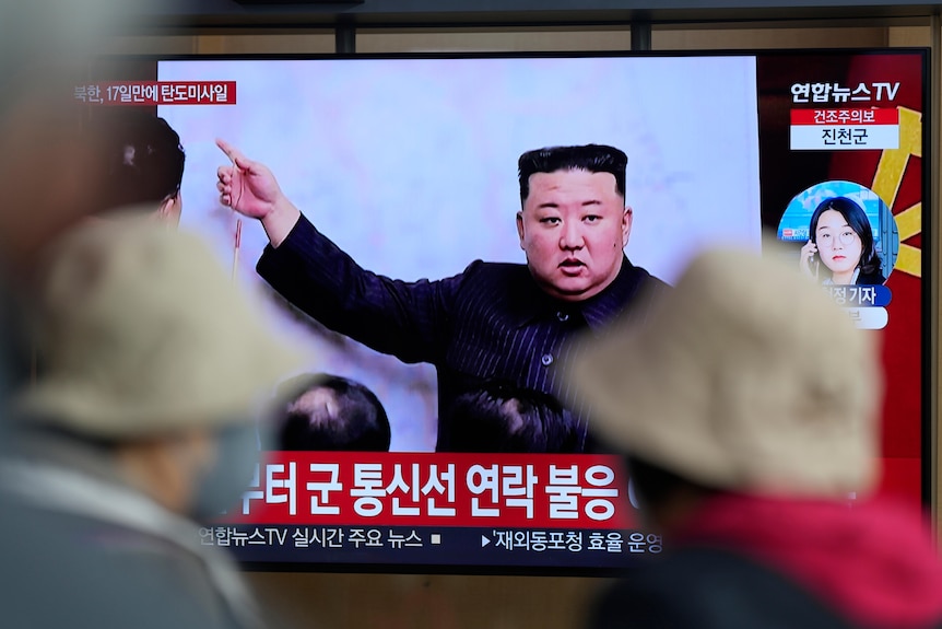 Kim Jong Un on a television screen pointing