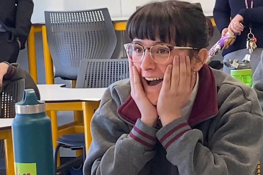 Tahlia Borg, wearing glasses with brown hair and a fringe, sitting in class and looking surprised