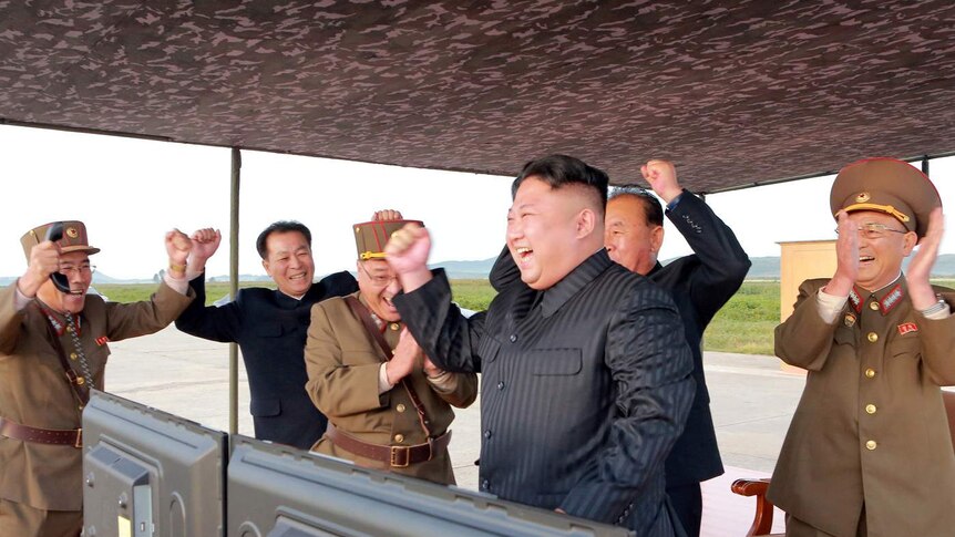 Kim Jong-un and his staff clap and fist bump to celebrate another successful launch