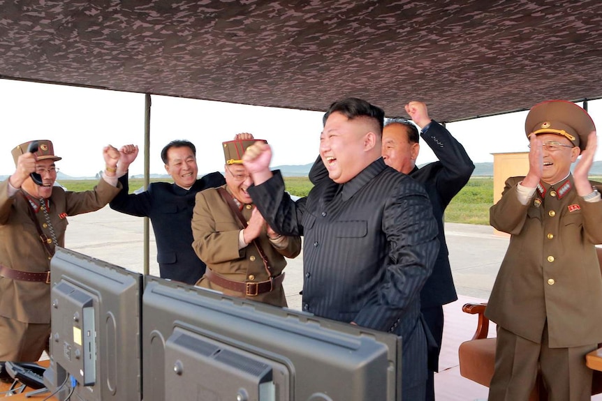 Kim Jong-un and his staff clap and fist bump to celebrate another successful launch
