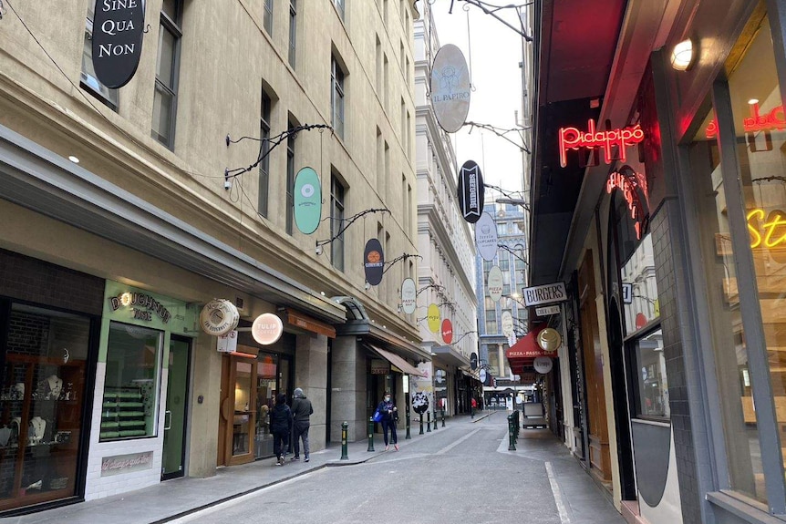 A Melbourne laneway can be seen with store signs but only a couple of people.