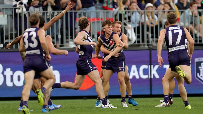 A group of Fremantle players run to Caleb Serong in celebration after his amazing goal.