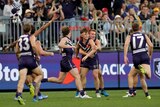 A group of Fremantle players run to Caleb Serong in celebration after his amazing goal.