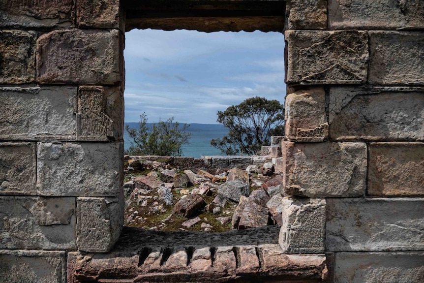 Picture of an old sandstone building the ocean in the background