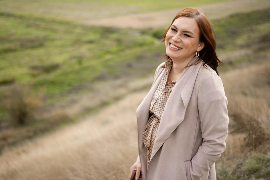  Anastasiia Yeva Domani stands in a field smiling. 