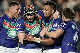 Four Warriors NRL players celebrate a try against the Dragons.
