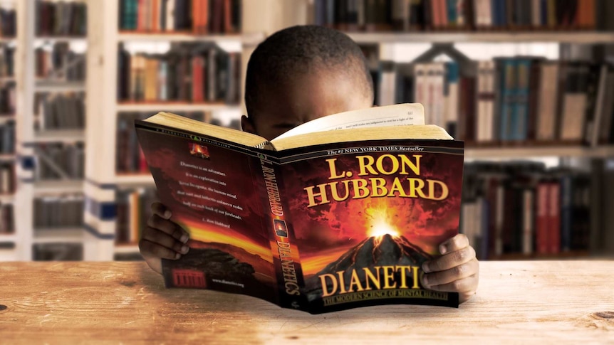 An image of a boy reading a book by L Ron Hubbard the founder of the Church of Scientology