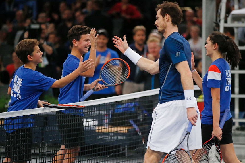 Britain's Andy Murray shakes hands with ball kids after on-court training session at Paris Masters.