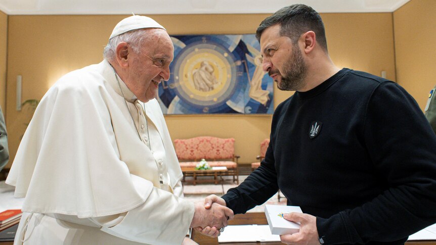 Pope Francis (L) shakes hands with Ukrainian President Volodymyr Zelenskyy.