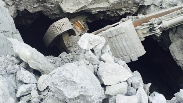 An excavator stuck upside down in hole from old underground mine workings