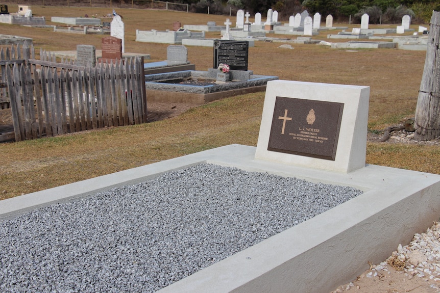 A new grave with other headstones behind