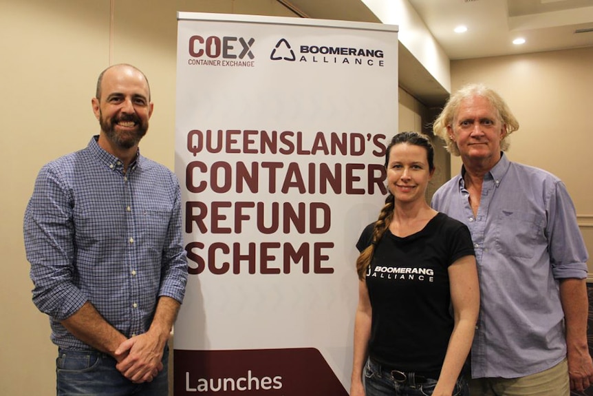 Adam Nicholson from CoEx, Kellie Lindsay and Toby Hutcheon from Boomerang Alliance stand in front of a sign on August 1, 2018.