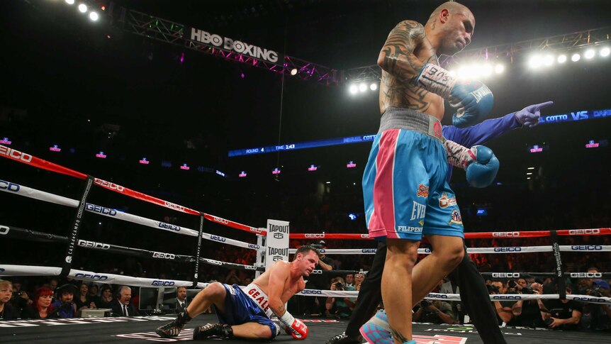 Miguel Cotto (R) walks away after knocking down Daniel Geale