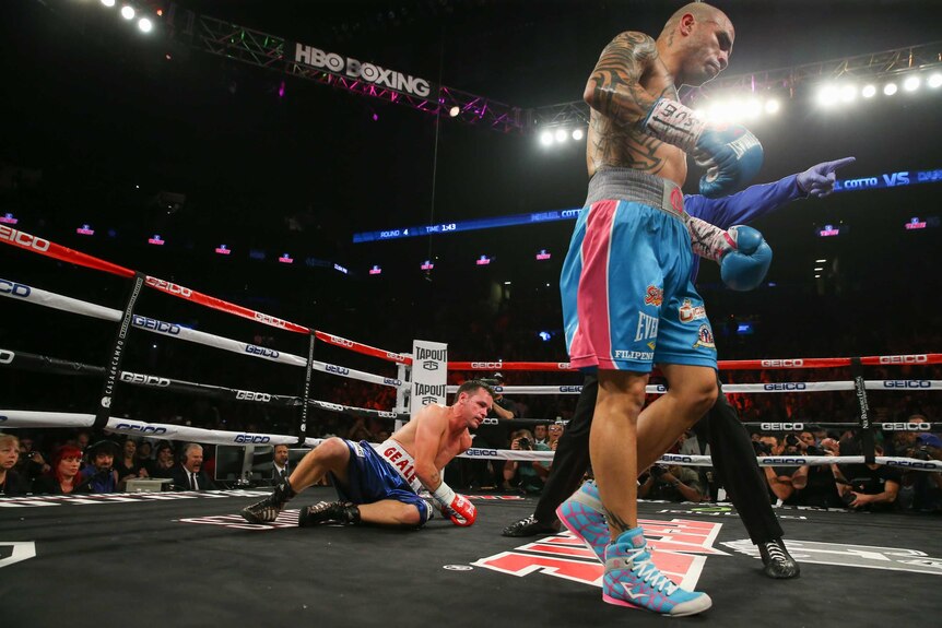 Miguel Cotto (R) walks away after knocking down Daniel Geale