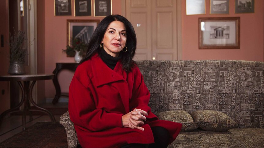 Rima Husseini sits on a couch in the Palmyra Hotel.