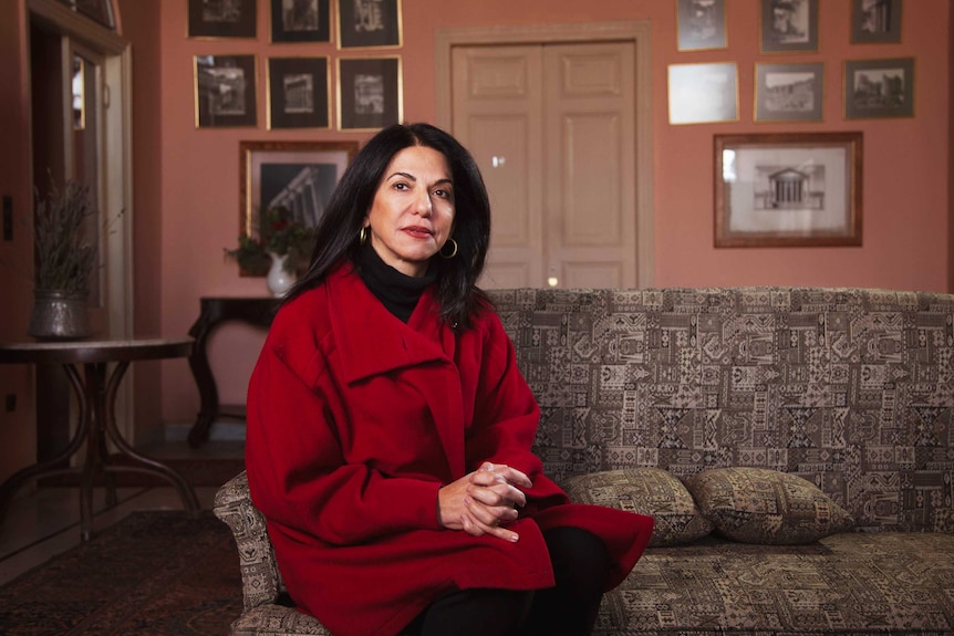 Rima Husseini sits on a couch in the Palmyra Hotel.