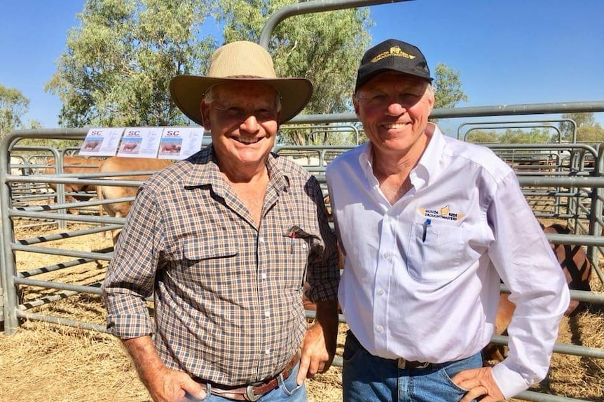 Two male pastoralists standing in front of cattle yards