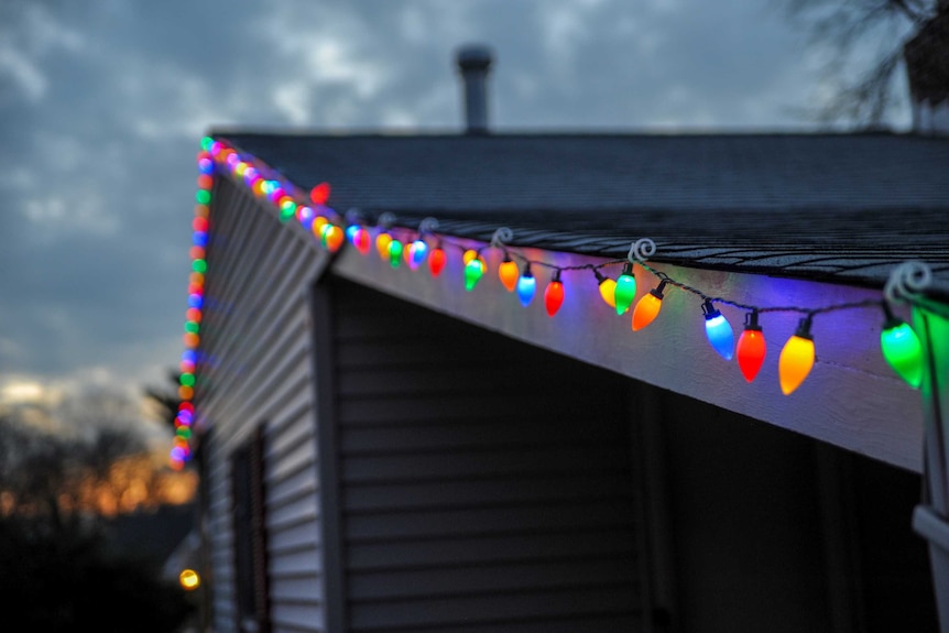 Christmas lights hang on a house awning.