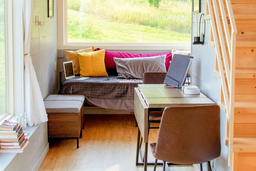 Interior of a tiny house, with stairs to the bedroom loft.