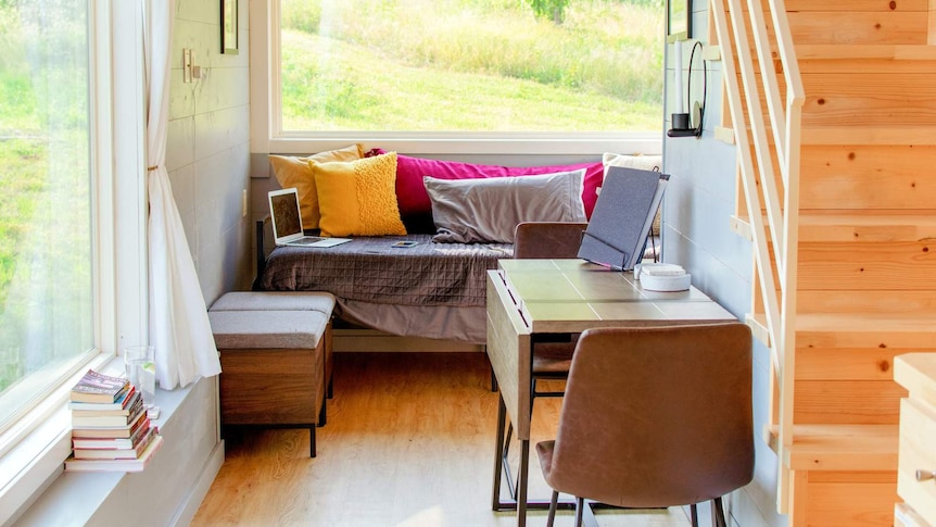 Interior of a tiny house, with stairs to the bedroom loft.