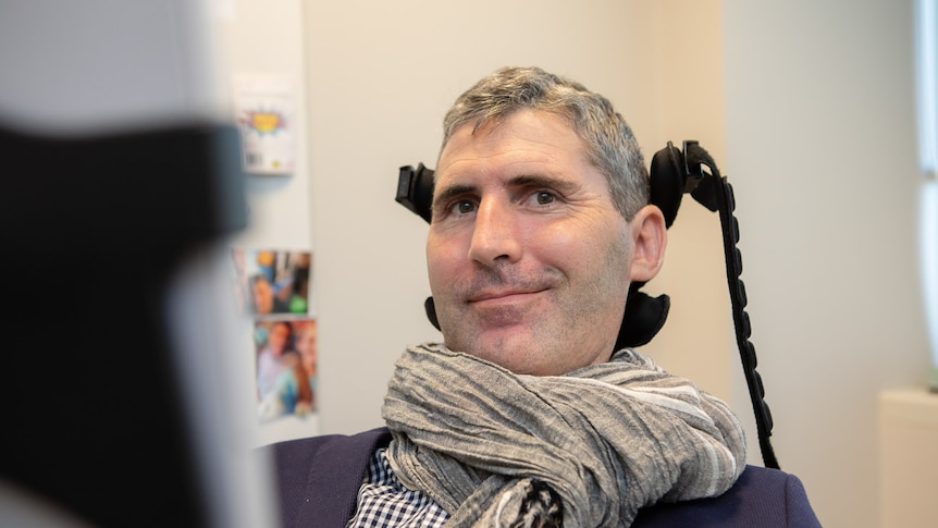 A man in an assistive wheelchair looking at the camera.