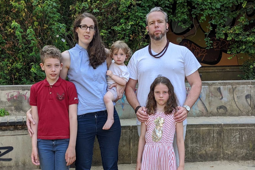 Laura Kool stands left, next to her son far left, as she holds another child. Her husband stands to her right behind daughter.