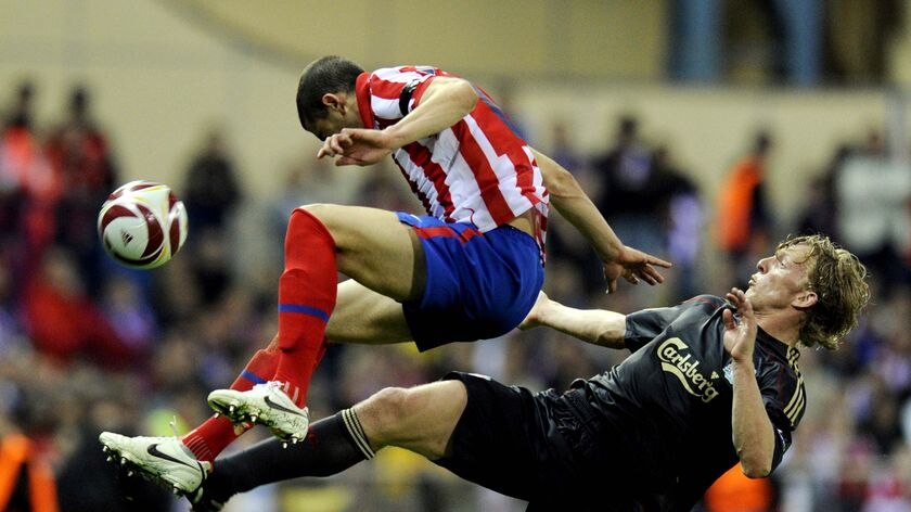 Atletico Madrid defender Alvaro Dominguez hurdles Dirk Kuyt.