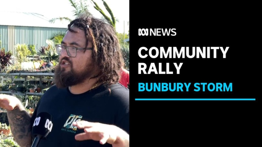Community Rally, Bunbury Storm: A man with beard and glasses speaks into an ABC reporter's microphone.