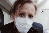 Fiona on the flight back to Australia, wearing a face mask.