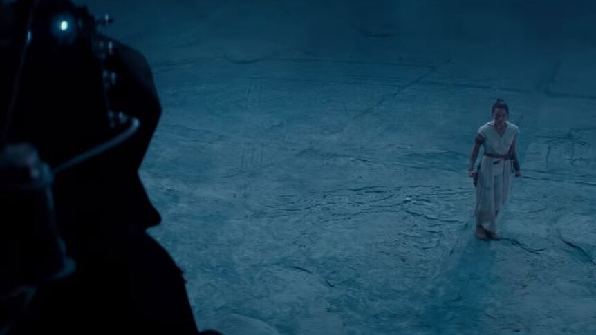 A still from the final Star Wars Episode IX: The Rise of Skywalker trailer with Rey looking at a character off screen.