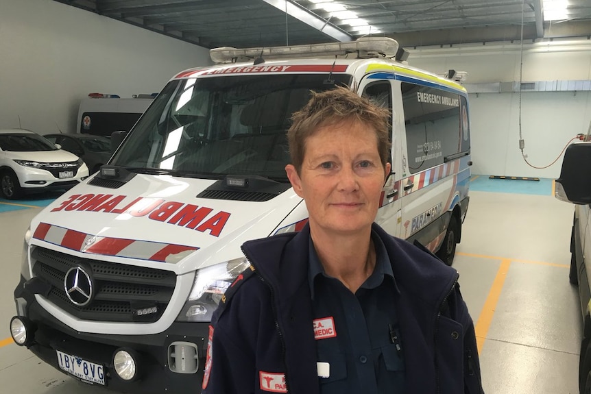 Andrea Wyatt stands in front of an ambulance.