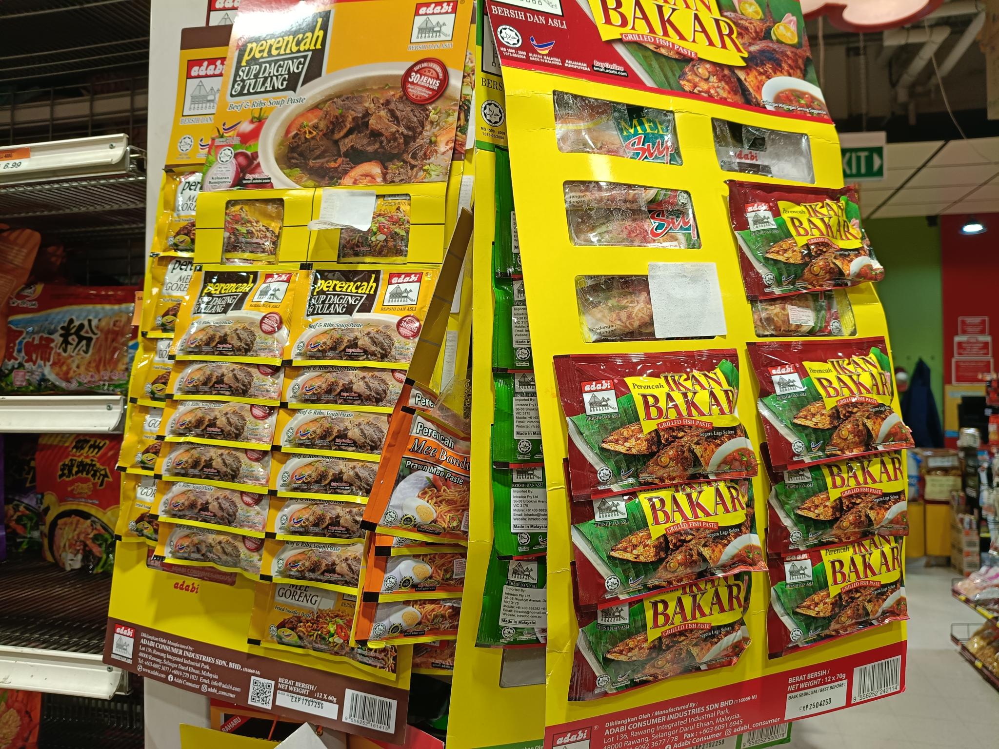 A number of products in small plastic packages sold individually hang on supermarket shelves.