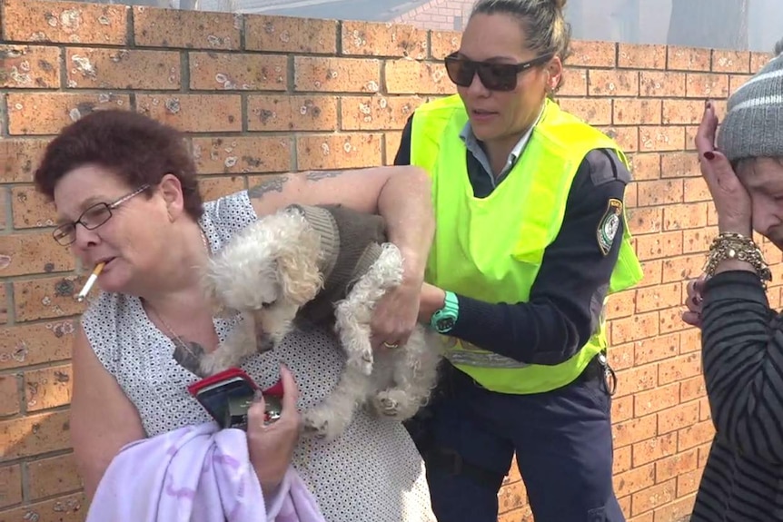 Three women, one carrying a dog