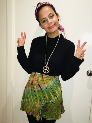 Young woman smiles and makes peace sign gestures
