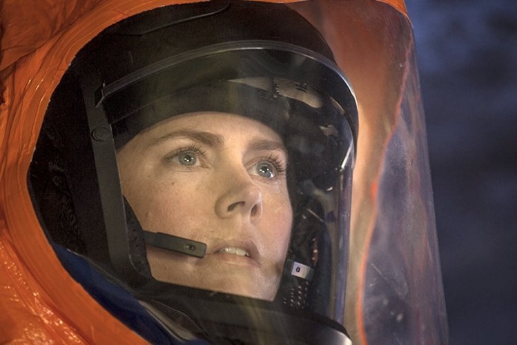 A close picture of a woman in an orange space suit.